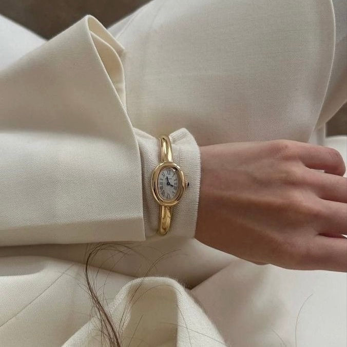 Oval Dial Paired with a Polished Gold Bangle .